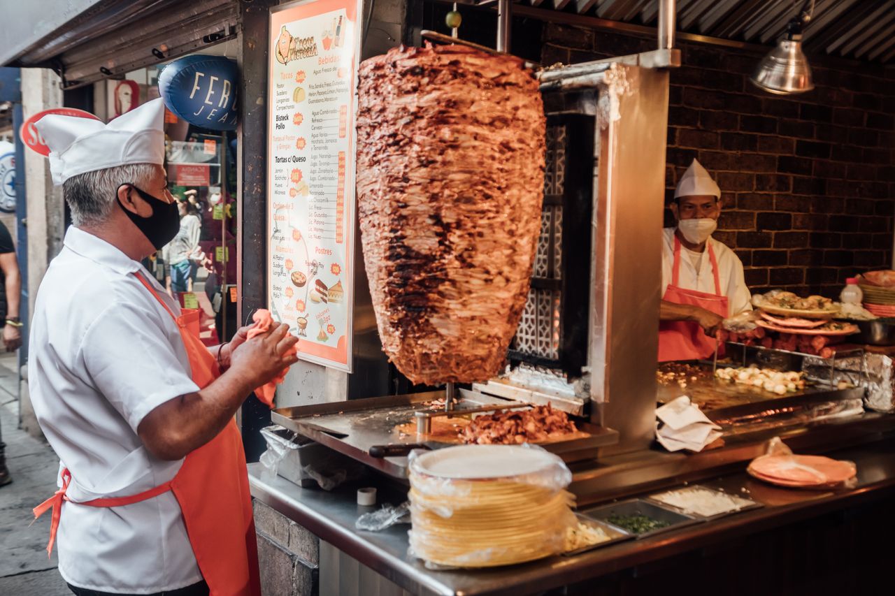 Taquero preparando tacos al pastor en su puesto